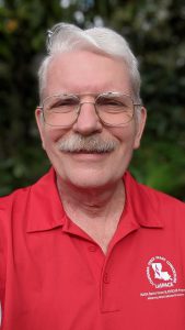 Head and shoulders picture of Greg Guzik wearing a red shirt with the LaSPACE Logo on it. 